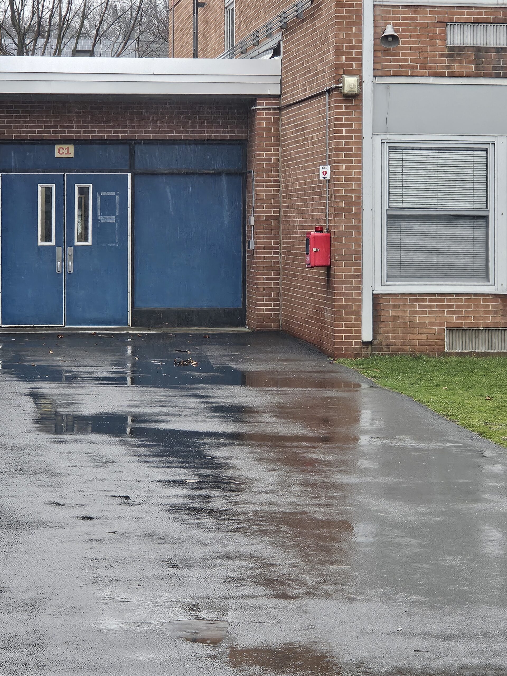 Tamaques Elementary AED is located on back of building in red box.  When looking at building from field, it is near the doors in the center of the building behind the swings.